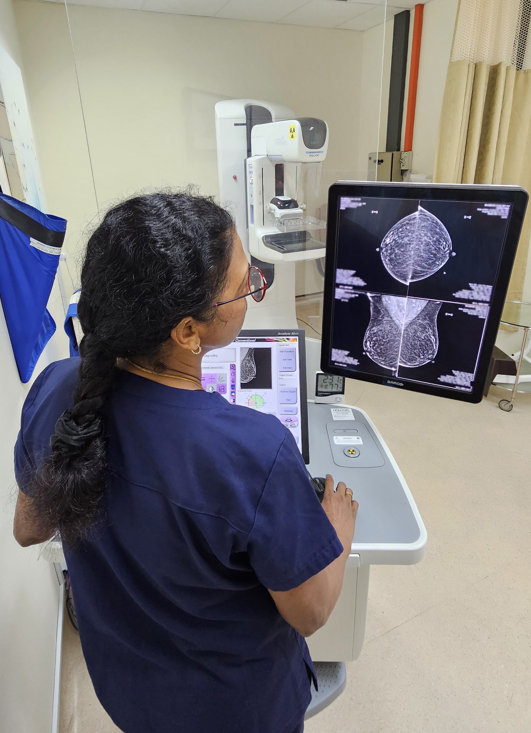 Radiographer assisting with mammogram screening report analysis | Mammography Singapore